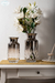 Jarrón de vidrio gris fume, ideal para darle un toque de elegancia a cualquier rincón de tu casa. Con un diseño sofisticado, es perfecto para lucir tus flores favoritas o simplemente como un objeto decorativo.

Características:

Medidas:
- Medida Chico: 3