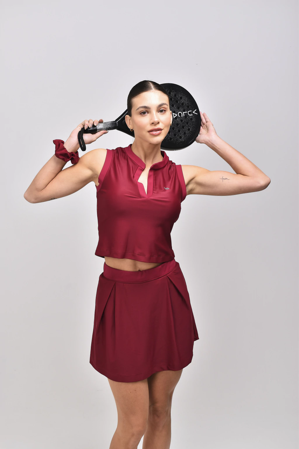 Saia Evasê Match Carmim Vulca em uso na quadra, pregas frontais e cós confortável