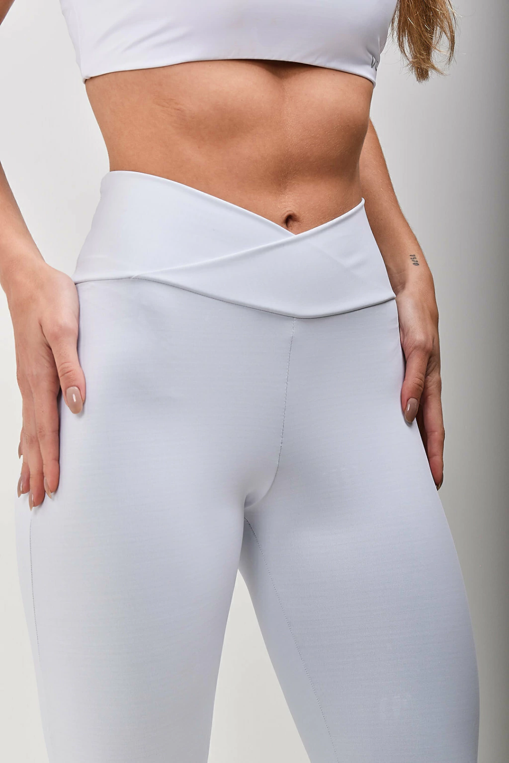 Detalhe do cós transpassado em V da Legging DuoCurve Branca da Vulca