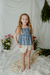 Nena con blusa Hortensia indigo, estampada con breteles de puntilla, combinado con short Azalea de lino off white
