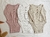 Variantes del body Boreales, de algodón con botones en pechera: en off white con lila, beige con verde, rosa con off white