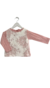 Remera de bebé confeccionada en jersey de algodón color rosa jaspeado y pechera de encaje.