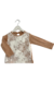 Remera de bebé confeccionada en jersey de algodón color dulce de leche jaspeado y pechera de encaje.