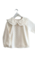 Remera de nena de algodón tramado y cuello baby color offwhite. 