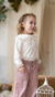 Nena con remera de algodón tramado y cuello baby color offwhite y pantalón de corderoy. 