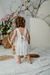 Beba de espalda con vestido Amapola bebé en off white