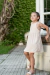 Nena  con vestido de tela de punto tramada en color beige. 