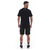 Camiseta casual masculina preta vista de costas, usada com bermuda e tênis.