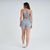 Modelo feminina usando shorts cinza mescla da linha Marcio May Sports, vista de costas.
