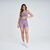 Modelo usando shorts femininos rosa mescla da marca Marcio May Sports, com top de fitness combinando.