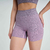 Conjunto de top e shorts fitness na cor rosa mescla, destacando detalhes do tecido e do design.