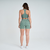 Modelo feminina usando top verde mescla e shorts, vista traseira, ideal para atividades de fitness.