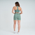 Modelo feminina usando shorts de fitness verde mescla da Marcio May, vista traseira.