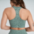 Top feminino de fitness na cor verde mescla, mostrando detalhes das costas e alças.