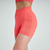 Conjunto de top e shorts fitness na cor laranja, destacando o design moderno e as texturas do tecido.