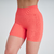 Shorts feminino laranja Marcio May, com detalhe em relevo na lateral e cintura alta, ideal para atividades físicas.