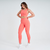 Modelo usando calça legging feminina laranja da Marcio May Sports, com detalhes texturizados e um top combinando.