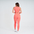Modelo usando calça legging feminina laranja com top, vista traseira, em ambiente claro.