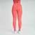 Mulher vista de costas usando calça legging laranja e top combinando, com tênis brancos.