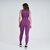 Mulher usando calça legging feminina Marcio May Sports Romilla na cor uva, vista de costas.