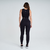 Calça legging feminina preta da marca Marcio May Sports, vista de trás, combinada com top preto.