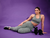Modelo usando calça legging feminina verde mescla da Marcio May Sports, posando ao lado de halteres em fundo roxo.