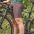 Bretelle masculino Marcio May Moove Café, utilizado por um ciclista ao lado de uma bicicleta em ambiente natural.