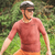 Homem usando a camisa de ciclismo Márcio May Aero Caju, com capacete e óculos de sol, em um ambiente natural.