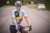 Homem usando a camisa azul e amarela do Kit Camisa Highline País do Ciclismo Bélgica, em uma bicicleta na estrada.