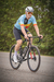 Atleta de ciclismo usando o kit camisa Highline País do Ciclismo Bélgica, pedalando em uma estrada.