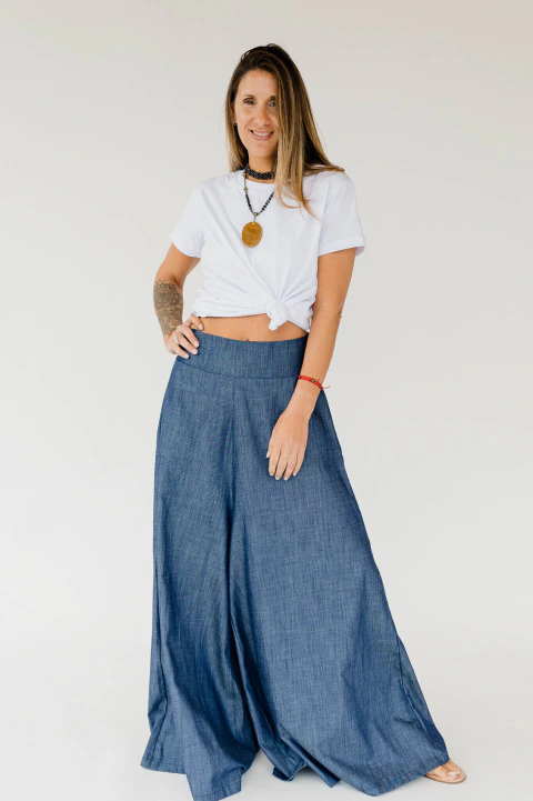 Mujer usando pantalón Helena de denim azul con piernas anchas y cintura elástica, combinando comodidad y estilo moderno.