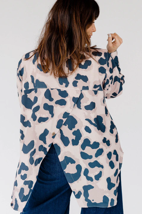 Vista trasera de una camisa camel de crepé con corte irregular en la espalda y estampado animal print, ideal para un look moderno y distintivo.