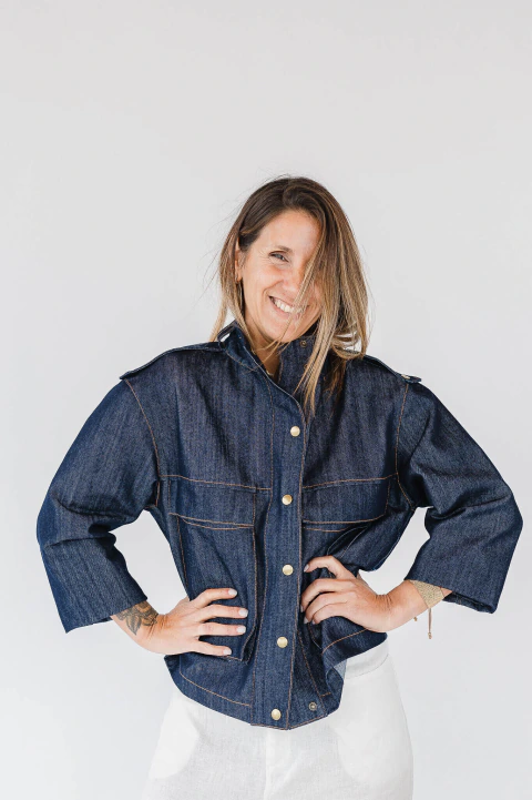 Mujer sonriendo que luce la Chaqueta Isadora Jeans de denim azul con botones metálicos y bolsillos delanteros, ideal para un look urbano.