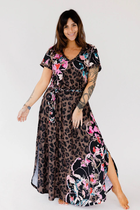 Vestido Felisa Modal Soft con estampado animal print y detalles florales, escote en V y lazo ajustable, modelo femenino posando sonriente.