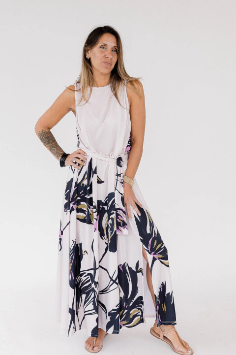 Vestido largo de seda fría color blanco con estampado floral y lazo en la cintura, modelo posando de pie.