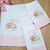Kit enxoval de bebê com fraldas personalizadas bordadas com ursinha sobre nuvem e nome "Giovanna".