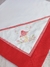 Cueiro de flanela branco com bordado de cogumelo vermelho e flores, com detalhes em vermelho e xadrez.