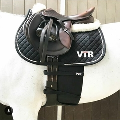 Faixa protetora preta de espora ajusta ao corpo do cavalo 