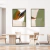 Composição de dois quadros decorativos com formas abstratas em tons de verde e terrosos, pendurados em uma parede branca.