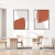Dois quadros decorativos com formas abstratas em tons de coral e cinza, emoldurados, pendurados em uma parede branca.