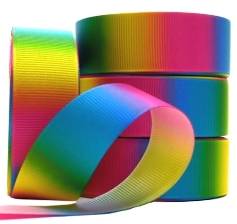 Rolos de fita de gorgorão com degrade em cores do arco-íris, apresentando tonalidades vibrantes e transições suaves entre azul, verde, amarelo, rosa e vermelho