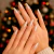 Unhas femininas com esmalte perolado dourado em fundo desfocado com luzes de Natal