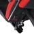 A imagem mostra uma cadeira gamer ergonômica moderna com um esquema de cores preto e vermelho. A cadeira possui apoios de braço ajustáveis, um encosto alto com material de malha respirável e está montada em uma base de estrela de cinco pontas com rodízios