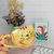 Taza amarilla con diseño de gatito, ideal para uso diario en la cocina.