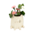 Maceta de cerámica en forma de gatito con flores rosadas y hojas verdes.