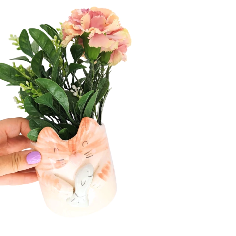 Maceta en forma de gato con flores y hojas verdes.