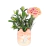 Maceta de cerámica con diseño de gato sosteniendo un pez, decorada con flores artificiales verdes y rosas.