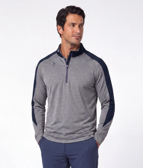 Buzo rafa, de hombre. Con manga raglan y recorte en la manga en color azul con un diseño "triangular" que llega hasta el puño. Puño y cintura añadida, cuello alto con medio cierre. Combinacion de gris melange en cuerpo y manga y azul en cuello y recorte e