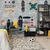 Habitación juvenil decorada con empapelado de patinetas, una silla moderna, y una alfombra con patrones, ideal para aficionados al skate.