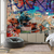 Empapelado de pared con diseño de graffiti colorido sobre ladrillos, decorando un ambiente moderno.